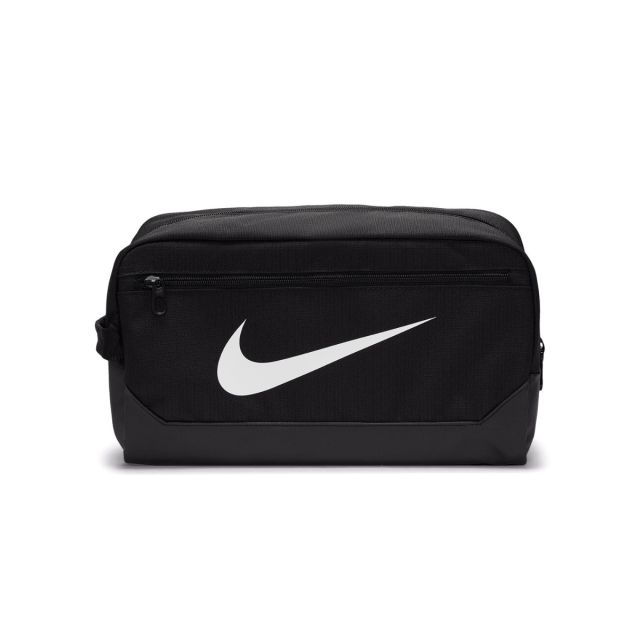 Black Nike Brasilia shoe bag on a white background. Durable rectangular duffel-style bag with large white Nike Swoosh logo on the front, dual zippered compartments, side carry handle, and black base panel for added protection. Designed for separate shoe s